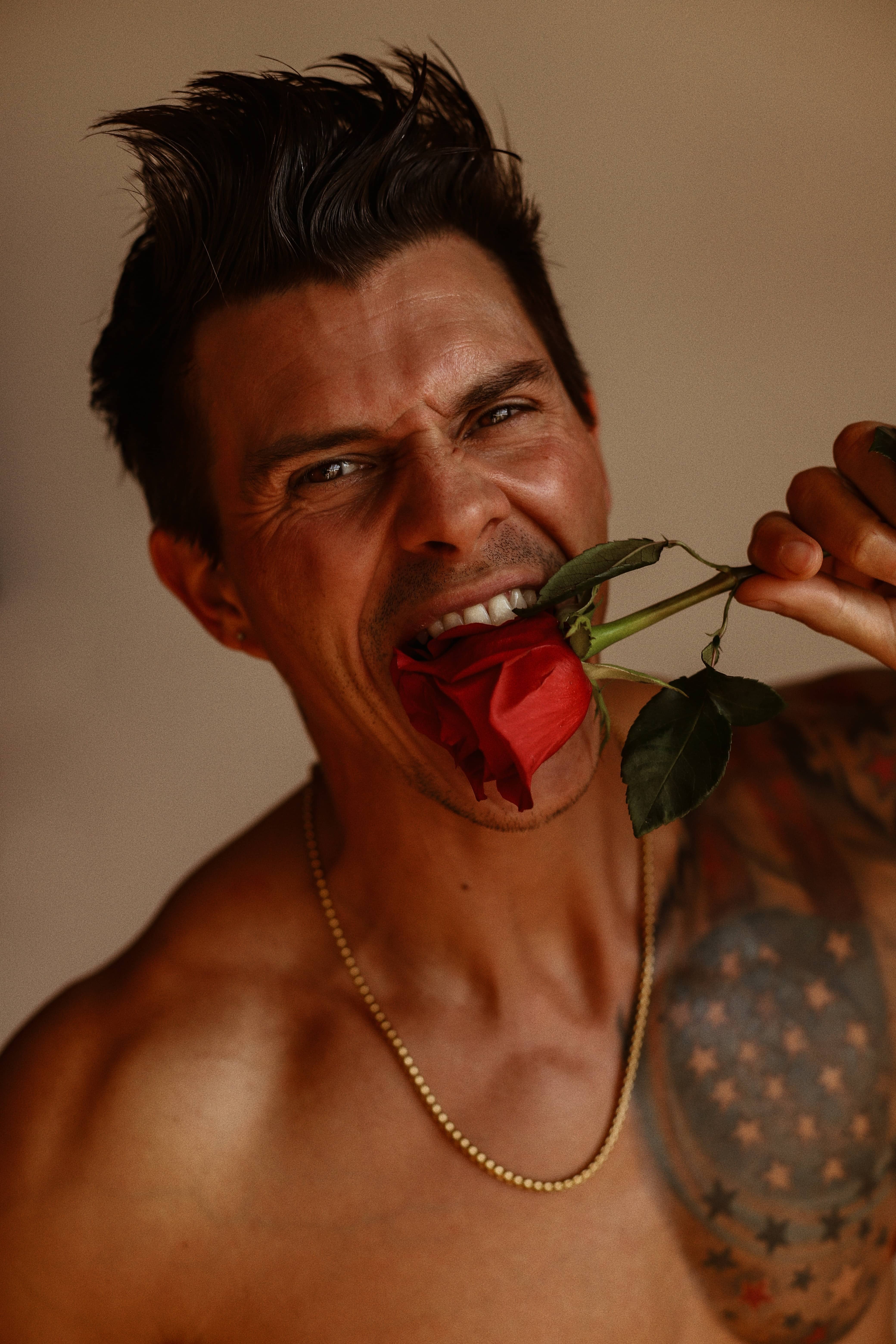 Kenny Braasch biting a red rose